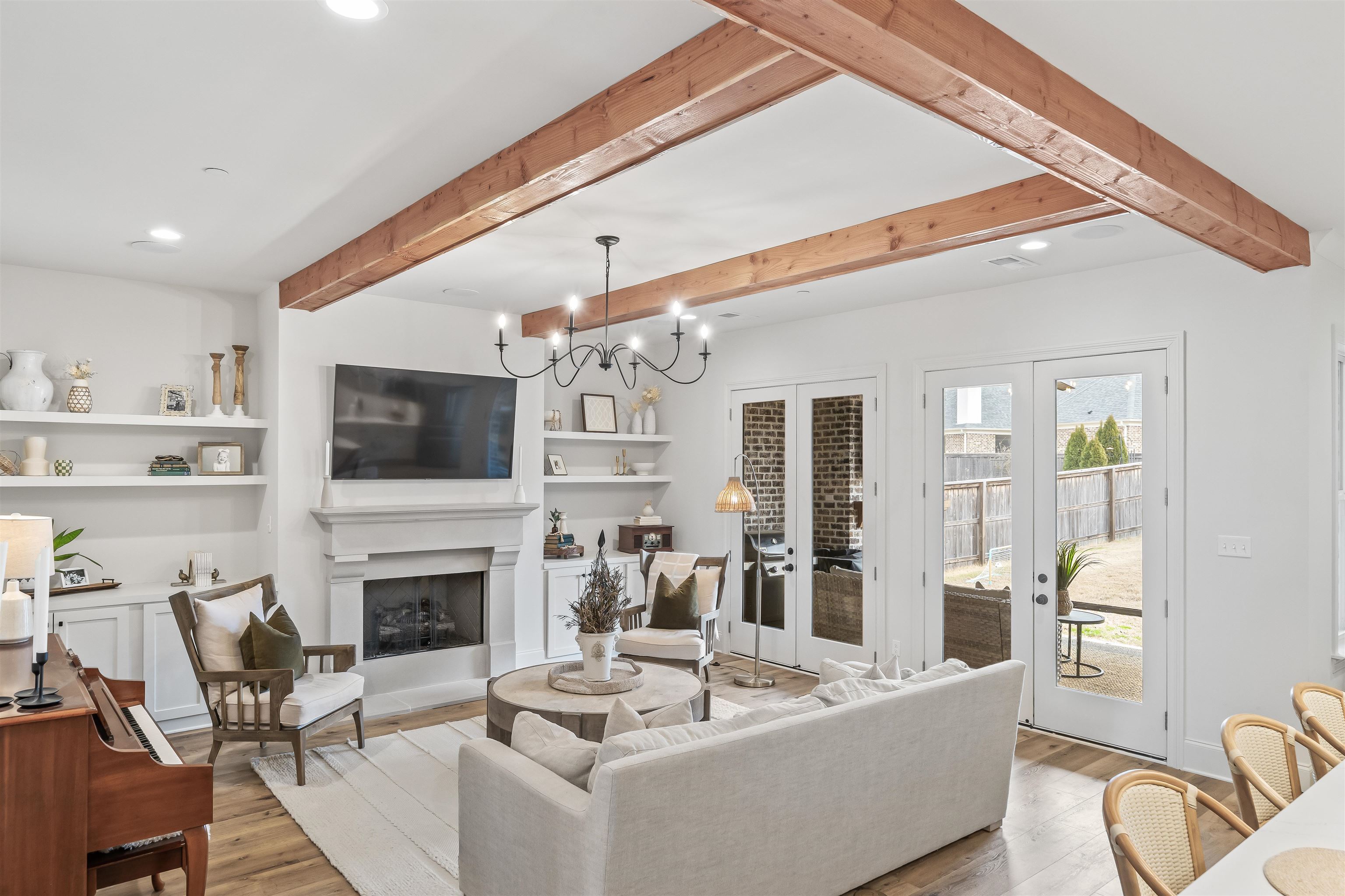 220 Mary Taylor Way Piperton, TN 38017 - Photo 8 of 36 Living room featuring light wood-style floors, beam ceiling, a fireplace with raised hearth, suspended lighting, and built in features
