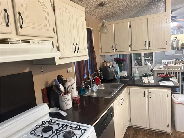 a kitchen with stainless steel appliances granite countertop a sink stove and cabinets