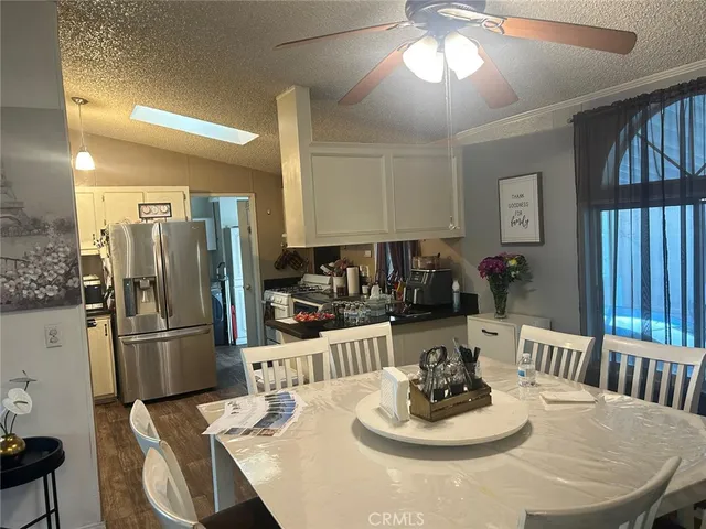 a dining room with wooden floor a chandelier a wooden table and chairs