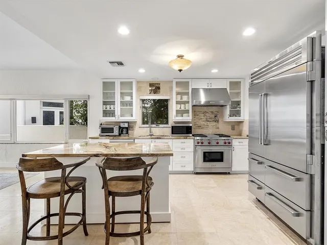 a kitchen with stainless steel appliances granite countertop a sink and cabinets