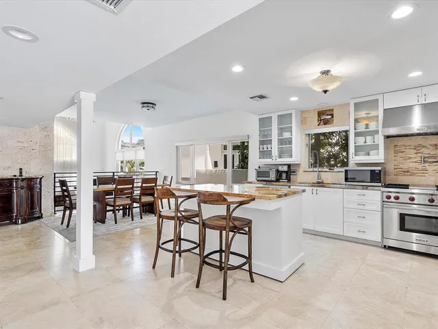 a living room with furniture a dining table and kitchen view with wooden floor
