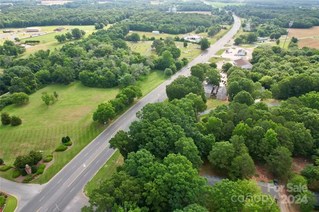 an aerial view of residential houses with outdoor space and trees