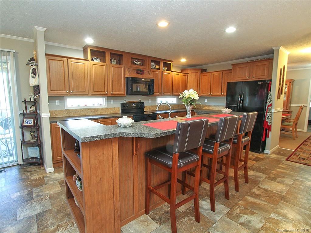 4027 Pink Plyler Road Lancaster, SC 29720 - Photo 20 of 34 a kitchen with stainless steel appliances granite countertop a table chairs sink refrigerator and microwave