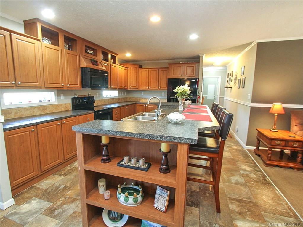 4027 Pink Plyler Road Lancaster, SC 29720 - Photo 22 of 34 a room with stainless steel appliances kitchen island granite countertop a table chairs sink and cabinets