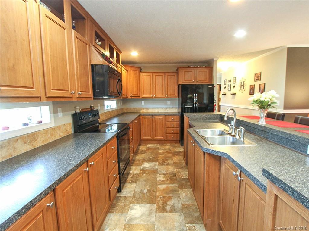 4027 Pink Plyler Road Lancaster, SC 29720 - Photo 24 of 34 a kitchen with granite countertop a sink a counter top space appliances and cabinets