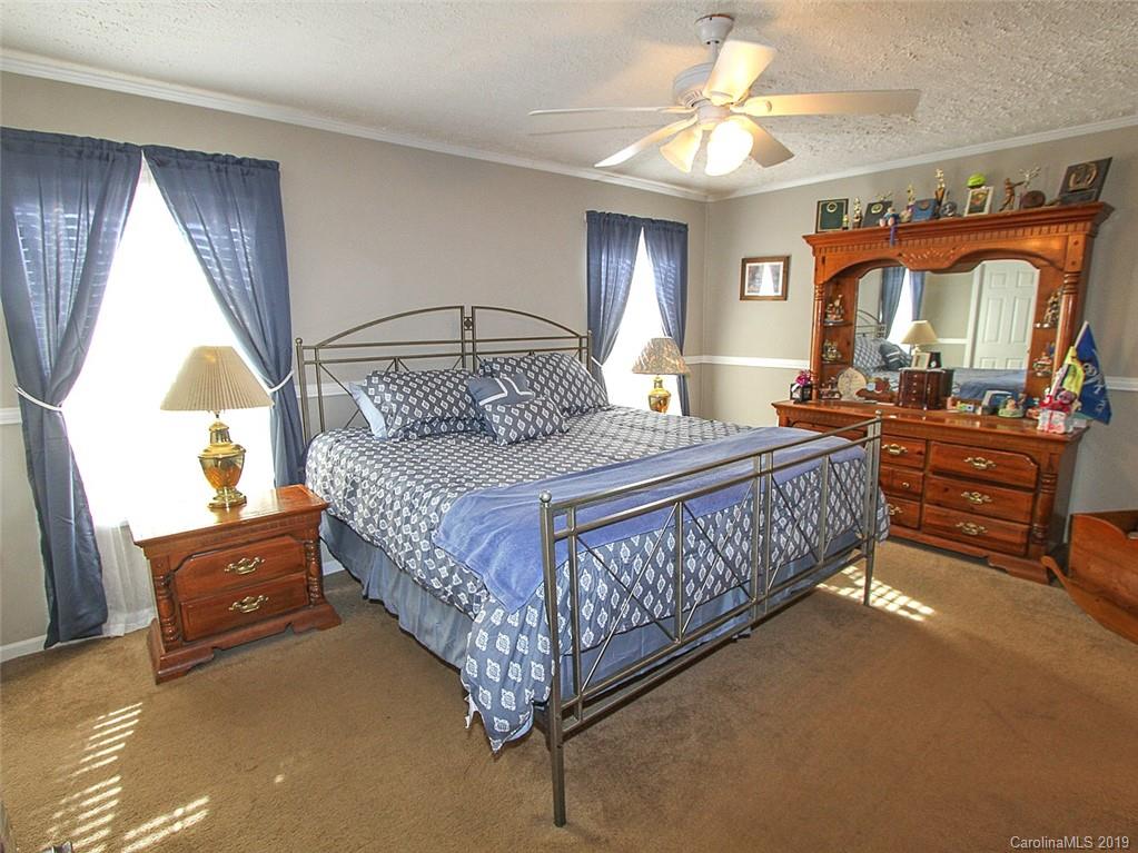 4027 Pink Plyler Road Lancaster, SC 29720 - Photo 27 of 34 a bedroom with a bed window and a chandelier