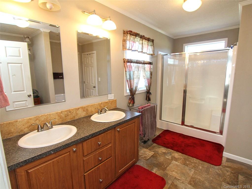 4027 Pink Plyler Road Lancaster, SC 29720 - Photo 28 of 34 a bathroom with 2 sink tub and a mirror