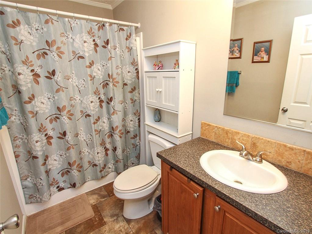 4027 Pink Plyler Road Lancaster, SC 29720 - Photo 31 of 34 a bathroom with a granite countertop sink toilet and shower