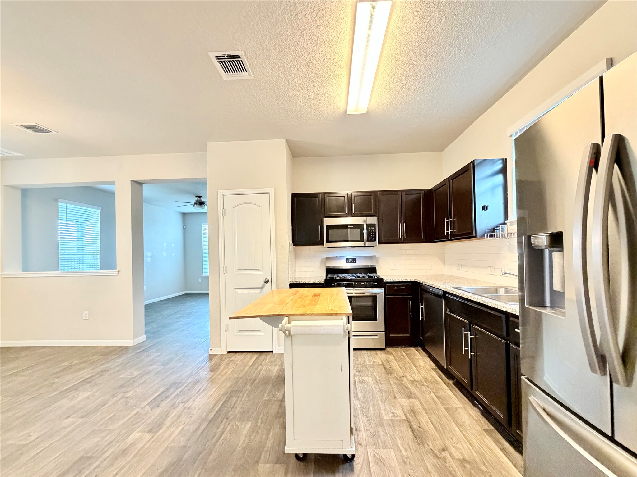 10502 Fulton Avenue Austin, TX 78754 - Photo 10 of 36 A contemporary kitchen space boasts stainless steel appliances and durable wood flooring.