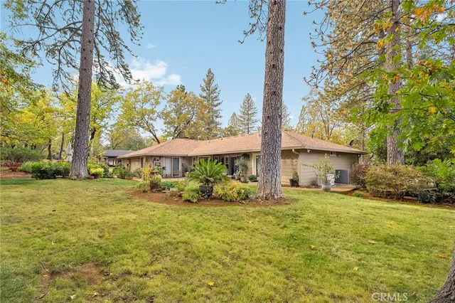 a view of a chair and table in backyard of the house