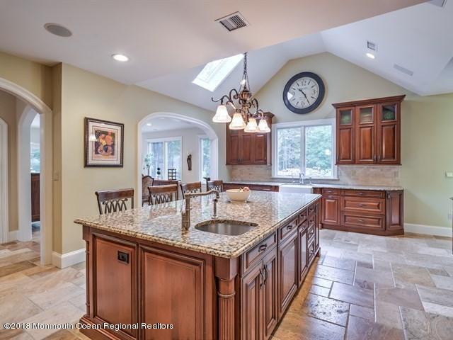 19 Russell Road Freehold, NJ 07728 - Photo 16 of 68 a kitchen with stainless steel appliances granite countertop a stove and a clock on the wall