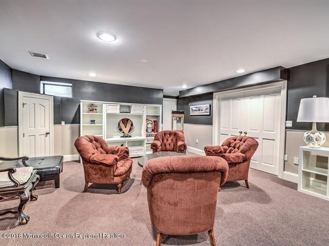 19 Russell Road Freehold, NJ 07728 - Photo 37 of 68 a living room with furniture a table and a bookshelf