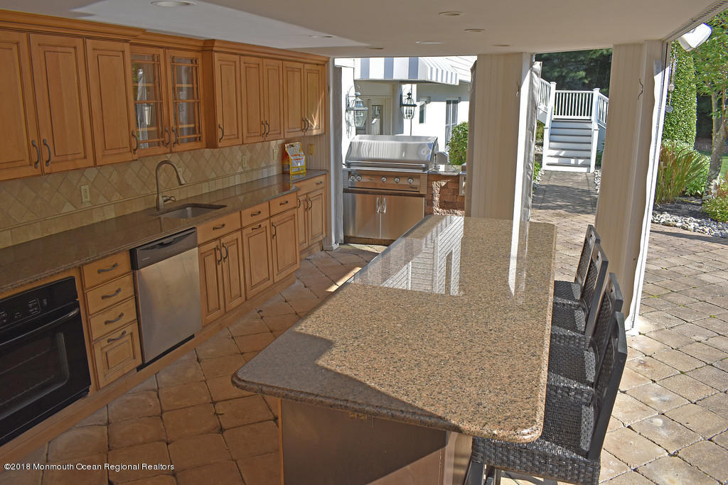19 Russell Road Freehold, NJ 07728 - Photo 47 of 68 a kitchen with stainless steel appliances granite countertop a refrigerator a stove and white cabinets with wooden floor