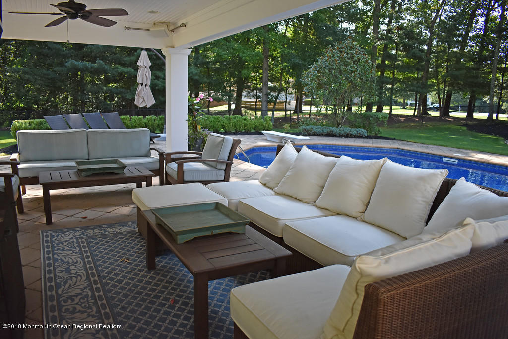 19 Russell Road Freehold, NJ 07728 - Photo 53 of 68 a view of a patio with couches and table and chairs with wooden fence and plants