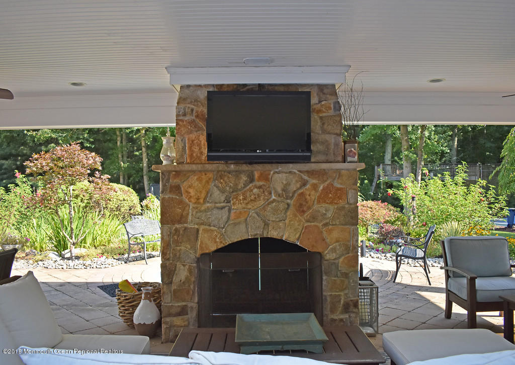 19 Russell Road Freehold, NJ 07728 - Photo 55 of 68 a living room with a fireplace and a flat screen tv
