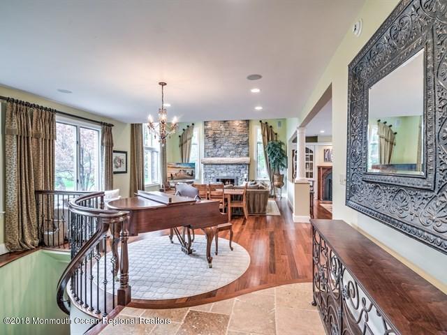 19 Russell Road Freehold, NJ 07728 - Photo 7 of 68 a view of a dining room and livingroom with furniture wooden floor a rug a potted plant and a chandelier