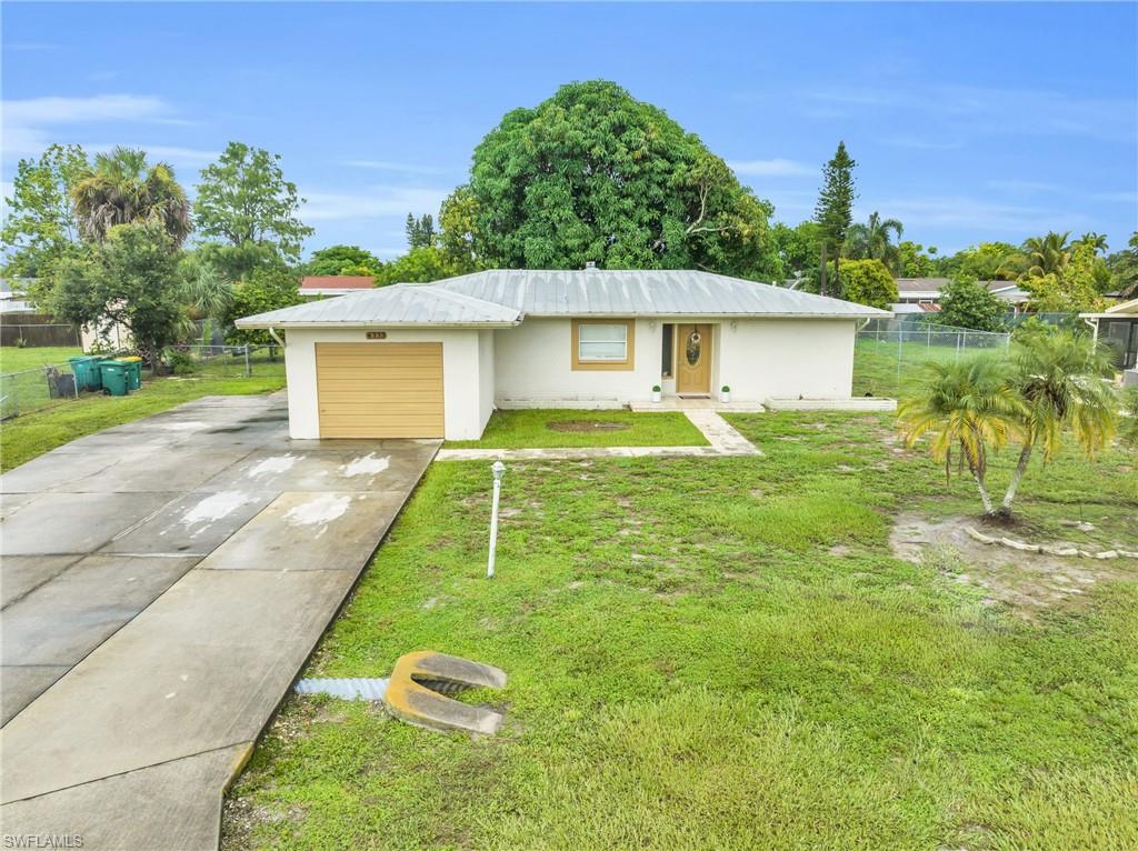4333 20th Place Southwest Naples, FL 34116 - Photo 26 of 31 a view of a house with a yard and a garage