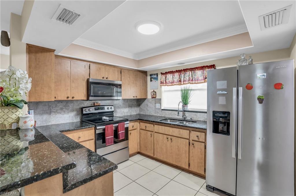 4333 20th Place Southwest Naples, FL 34116 - Photo 3 of 31 a kitchen with stainless steel appliances granite countertop a stove sink and microwave