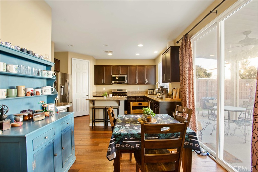 3866 Obsidian Road San Bernardino, CA 92407 - Photo 14 of 64 a view of kitchen with kitchen island stainless steel appliances refrigerator stove dining table and chairs