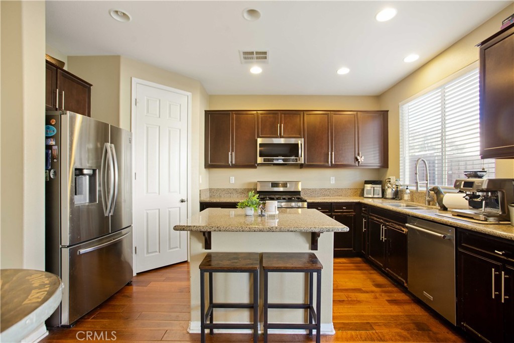 3866 Obsidian Road San Bernardino, CA 92407 - Photo 17 of 64 a kitchen with stainless steel appliances a refrigerator a stove a sink a stove a dining table and chairs