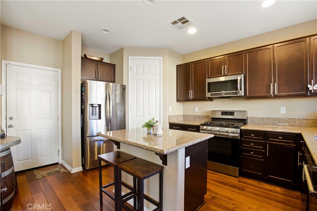 3866 Obsidian Road San Bernardino, CA 92407 - Photo 18 of 64 a kitchen with stainless steel appliances granite countertop a refrigerator stove microwave and sink