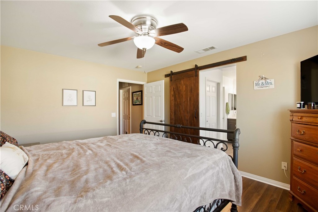 3866 Obsidian Road San Bernardino, CA 92407 - Photo 25 of 64 a bedroom with a large bed and a flat tv screen