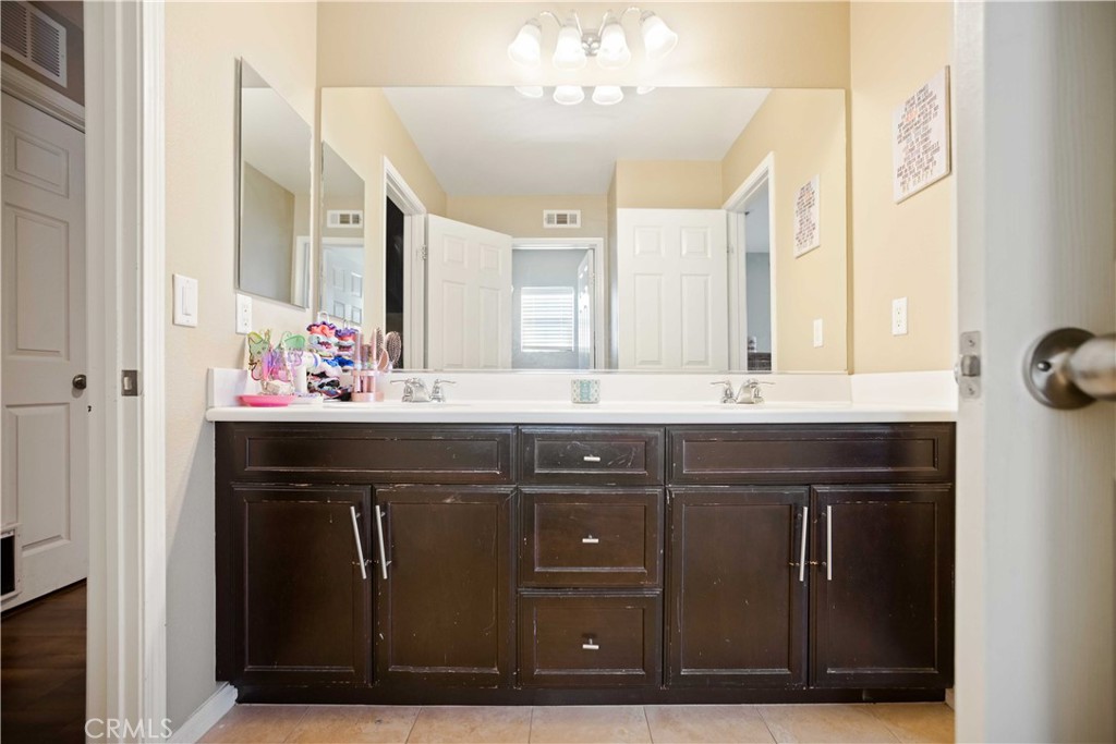 3866 Obsidian Road San Bernardino, CA 92407 - Photo 34 of 64 a bathroom with a sink vanity and a mirror