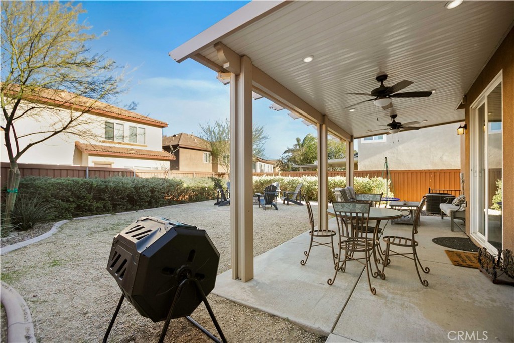 3866 Obsidian Road San Bernardino, CA 92407 - Photo 37 of 64 a view of a patio with a table chairs and a floor to ceiling window