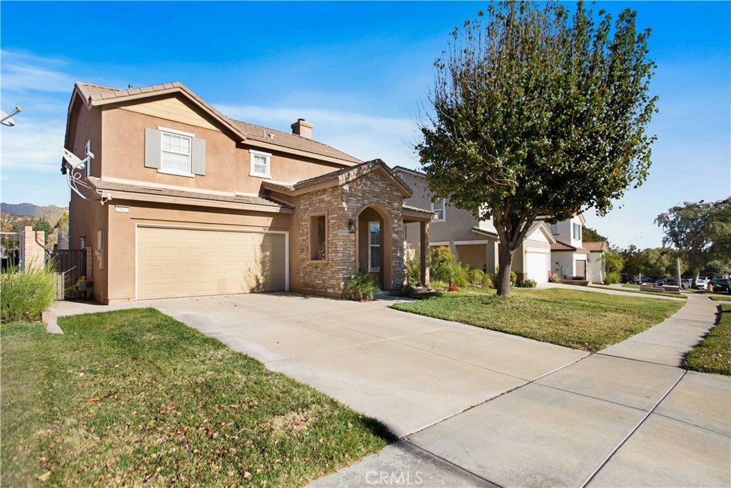 3866 Obsidian Road San Bernardino, CA 92407 - Photo 7 of 64 a front view of a house with a yard and garage