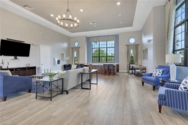 a living room with furniture a chandelier and a flat screen tv