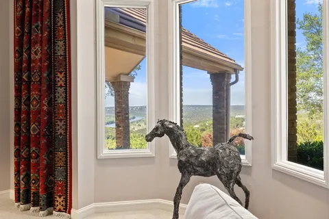 a living room with furniture a rug and a floor to ceiling window