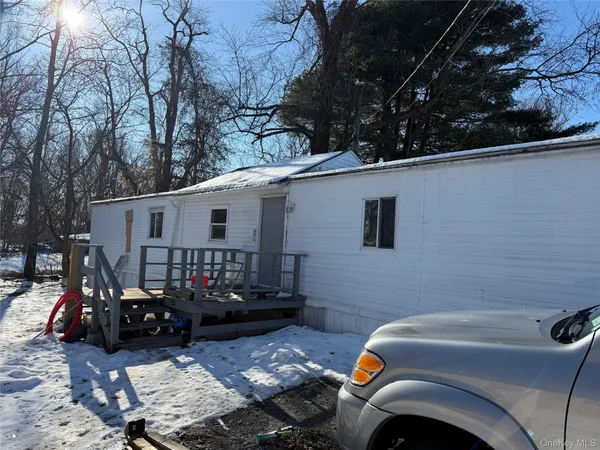 a front view of a house with cars parked