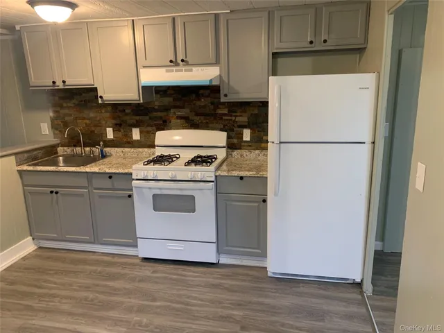 a kitchen with a white stove top oven and refrigerator