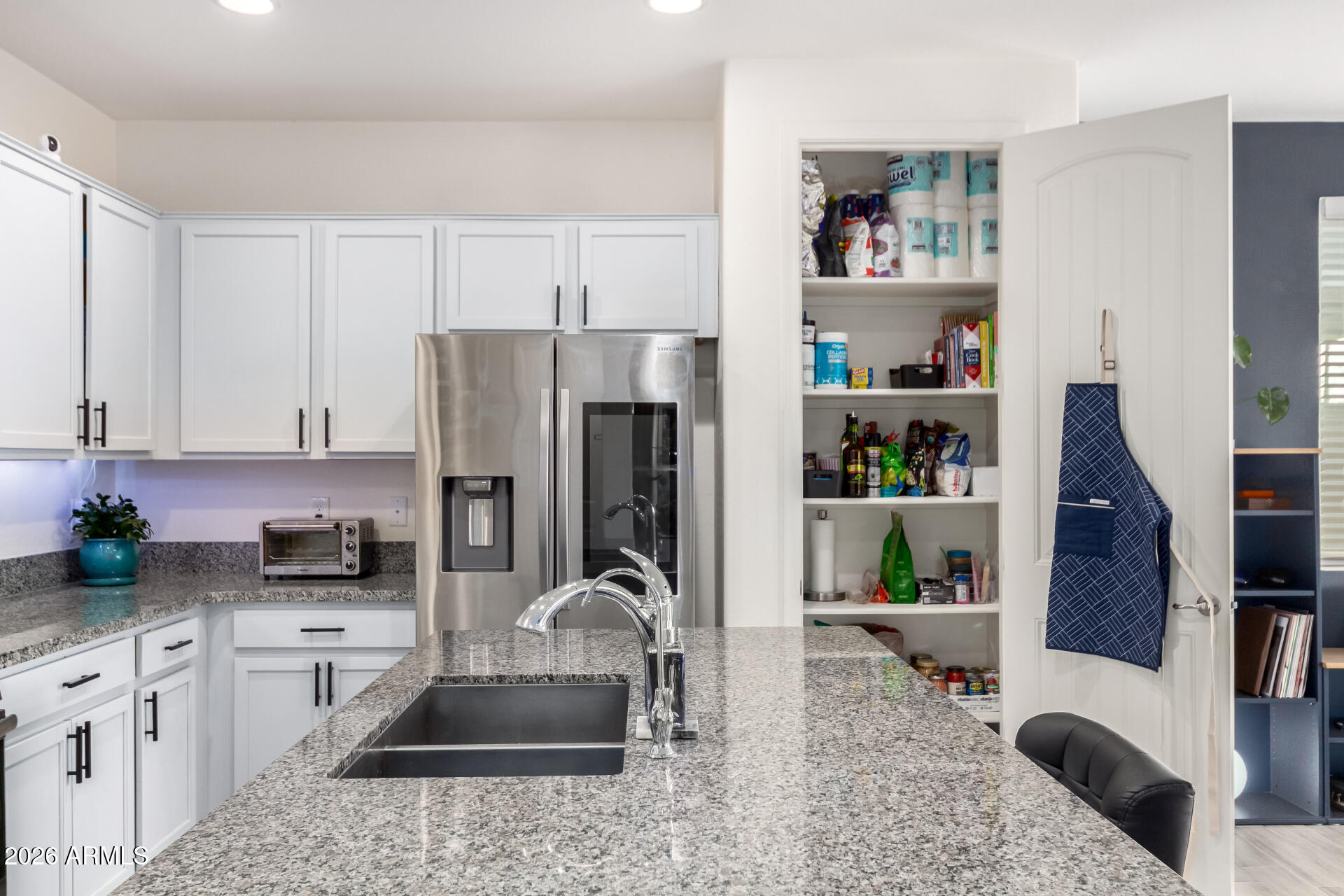21057 West Almeria Road Buckeye, AZ 85396 - Photo 11 of 49 a kitchen with stainless steel appliances granite countertop a refrigerator a stove and a sink with wooden floor