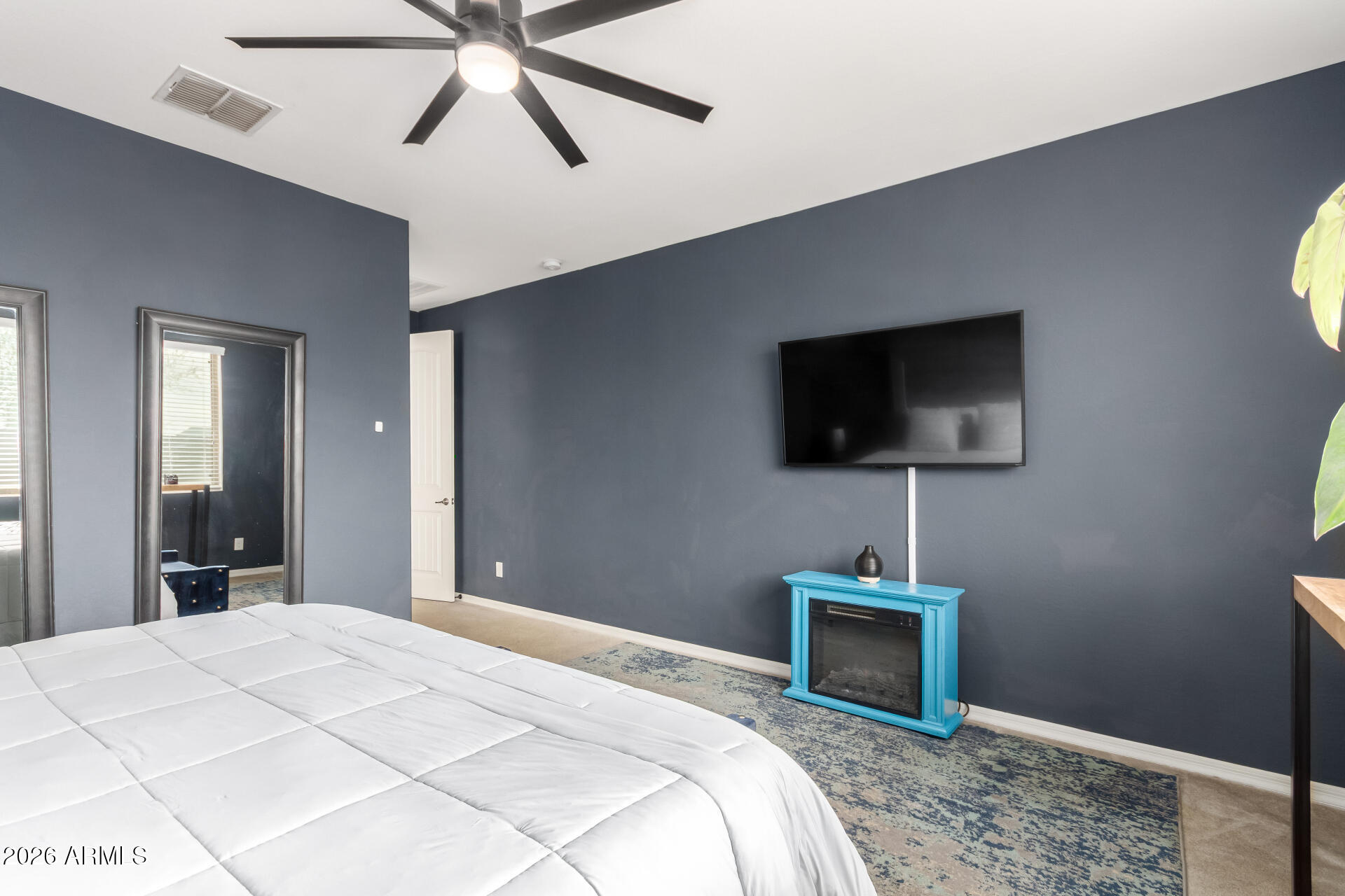 21057 West Almeria Road Buckeye, AZ 85396 - Photo 14 of 49 a bedroom with a bed and a flat screen tv