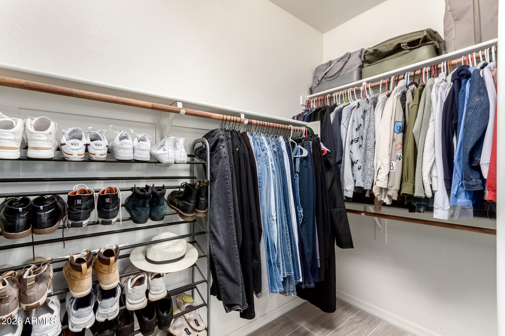 21057 West Almeria Road Buckeye, AZ 85396 - Photo 16 of 49 a view of walk in closet with clothes and shoes