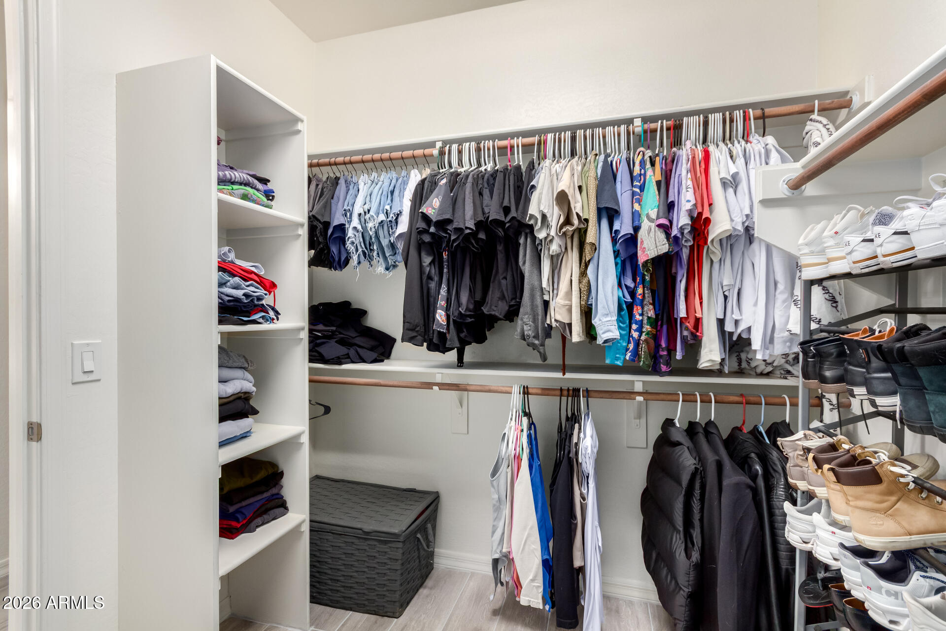 21057 West Almeria Road Buckeye, AZ 85396 - Photo 17 of 49 a view of walk in closet with clothes and shoes