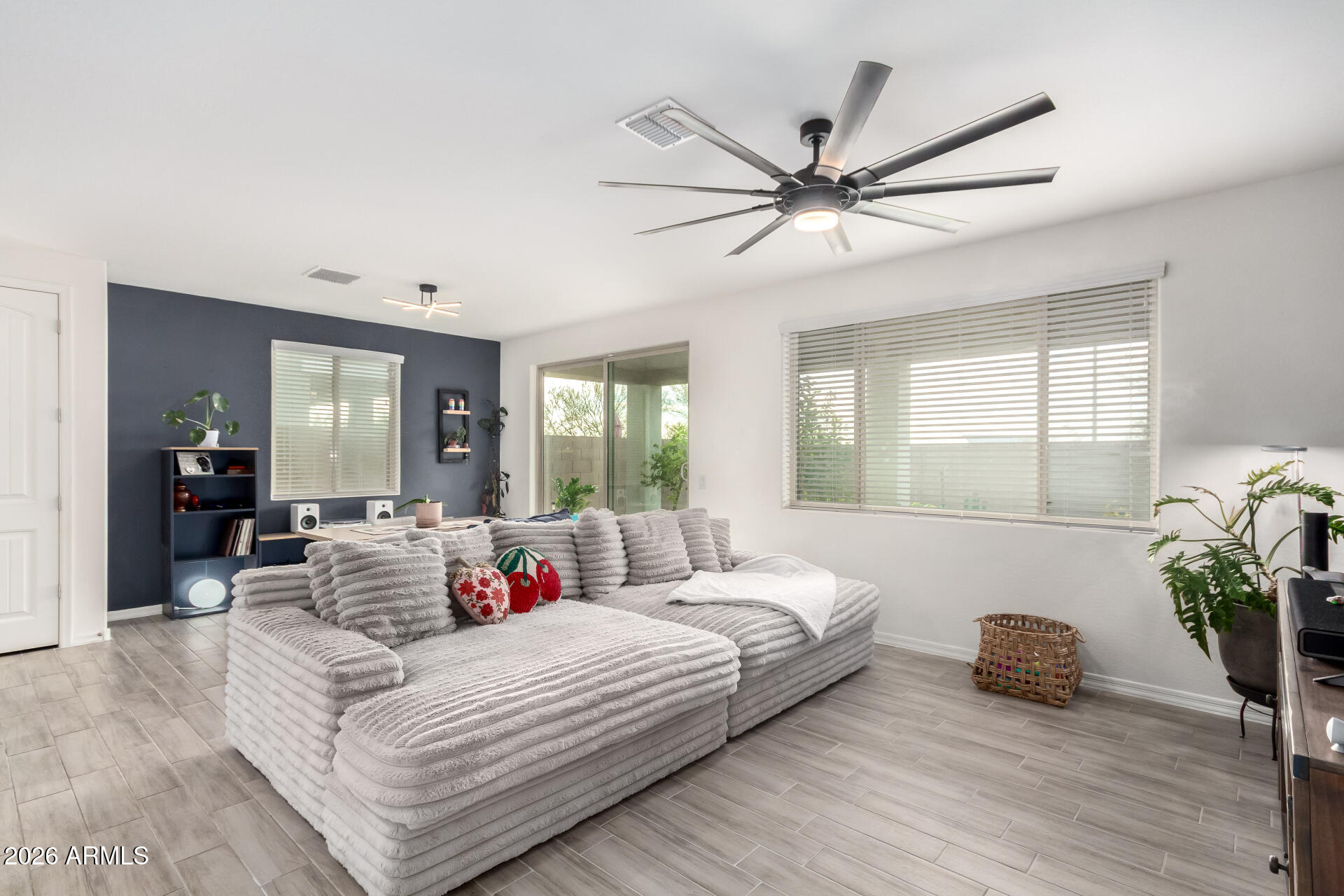 21057 West Almeria Road Buckeye, AZ 85396 - Photo 5 of 49 a bedroom with a large bed and a chandelier