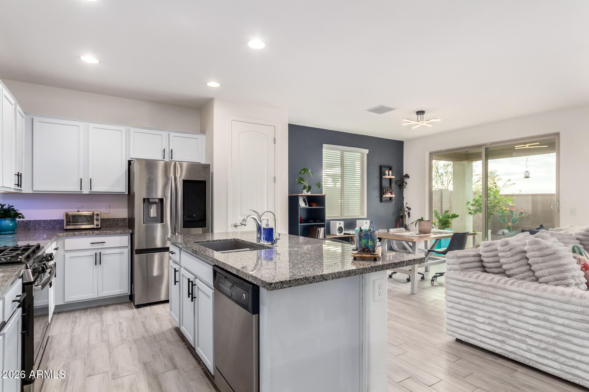 21057 West Almeria Road Buckeye, AZ 85396 - Photo 9 of 49 a kitchen with sink refrigerator and cabinets
