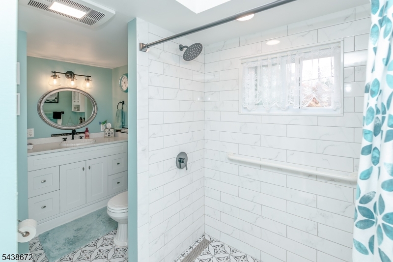 36 Main Street Flanders, NJ 07836 - Photo 18 of 31 a bathroom with a toilet a sink a mirror a window and vanity