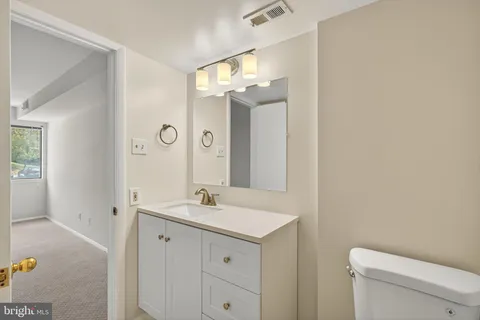 a bathroom with a sink a toilet and a mirror