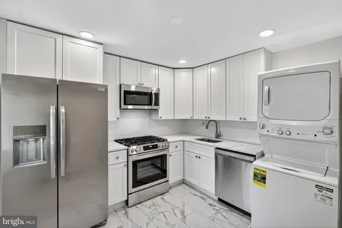 a kitchen with a sink appliances and cabinets