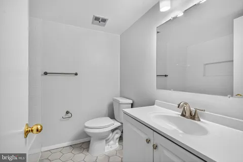 a bathroom with a granite countertop toilet a sink and a mirror