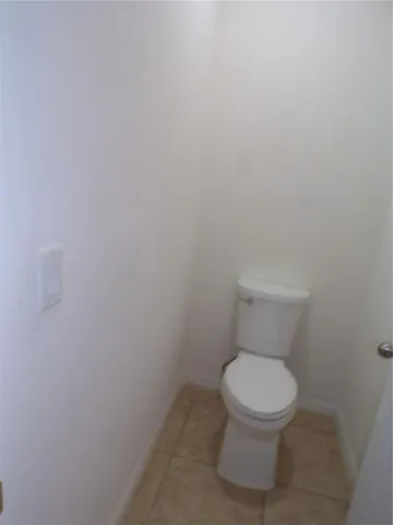 a white toilet sitting next to a white wall