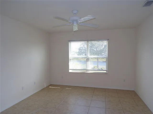 an empty room with a window and a ceiling fan