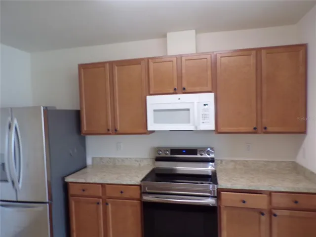 a kitchen with a refrigerator stove and cabinets