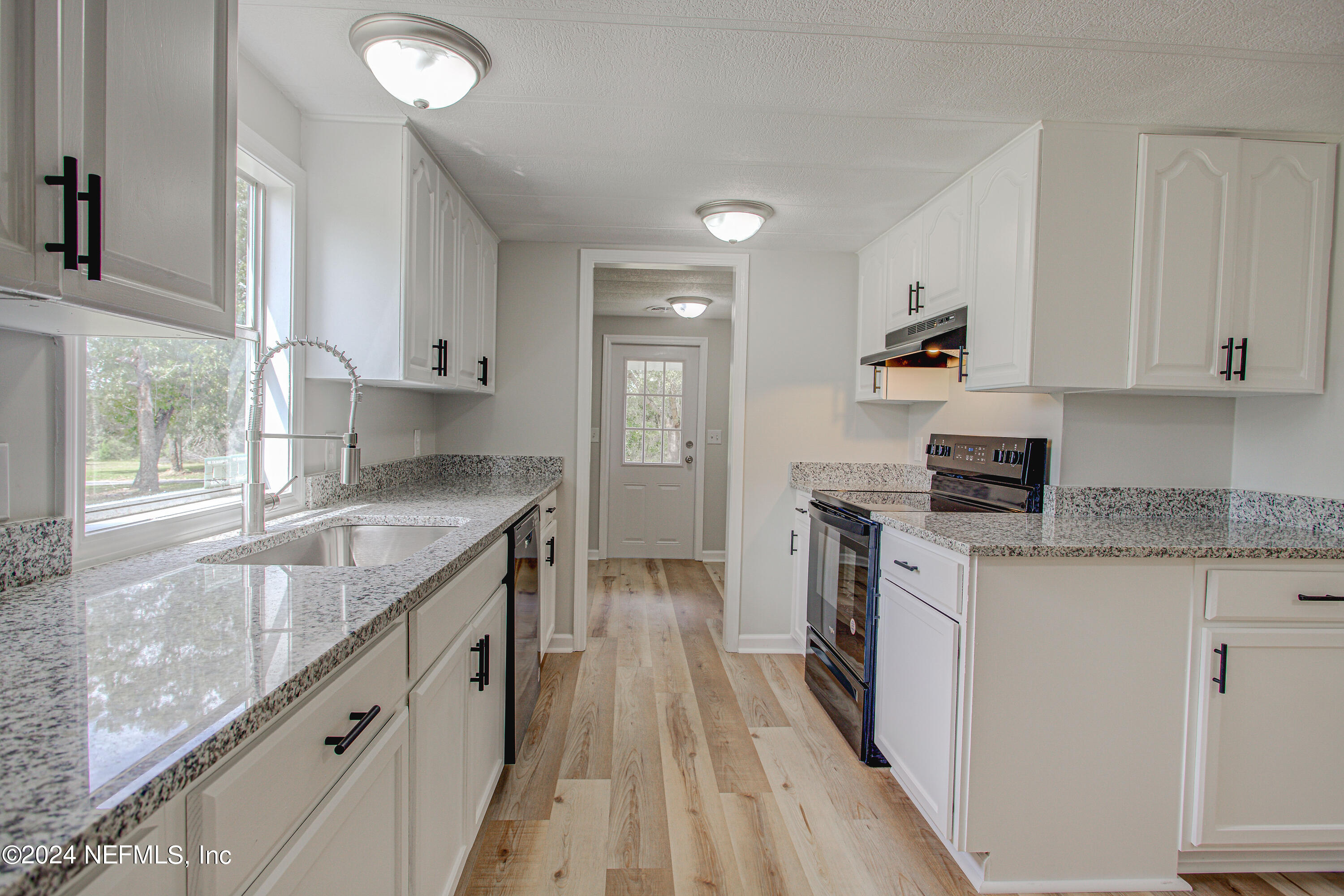 7677 Oak Forest Road Keystone Heights, FL 32656 - Photo 16 of 54 a kitchen with granite countertop a sink stove and cabinets