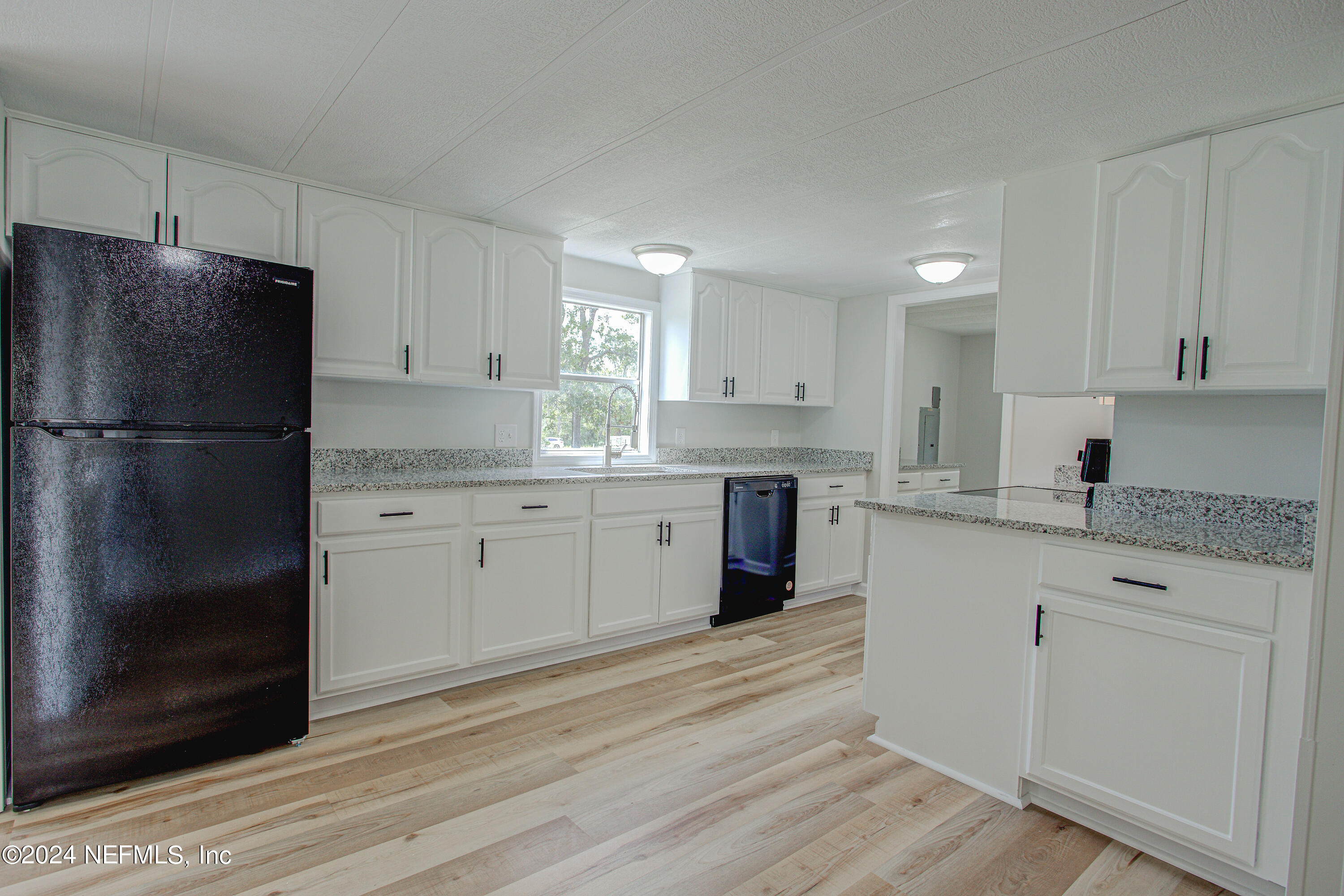7677 Oak Forest Road Keystone Heights, FL 32656 - Photo 18 of 54 a kitchen with a refrigerator a sink and dishwasher with wooden floor