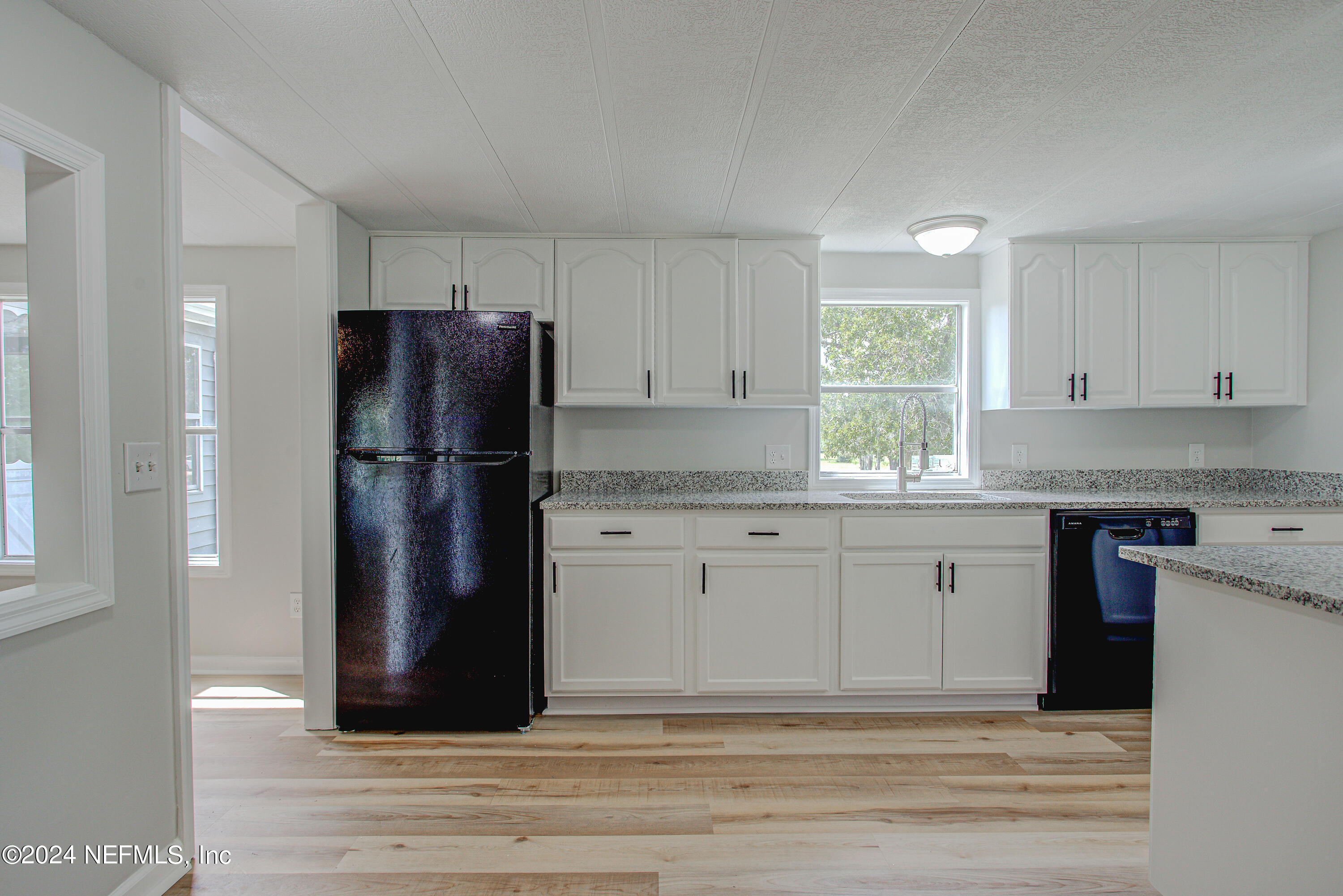7677 Oak Forest Road Keystone Heights, FL 32656 - Photo 19 of 54 a kitchen with a refrigerator and cabinets