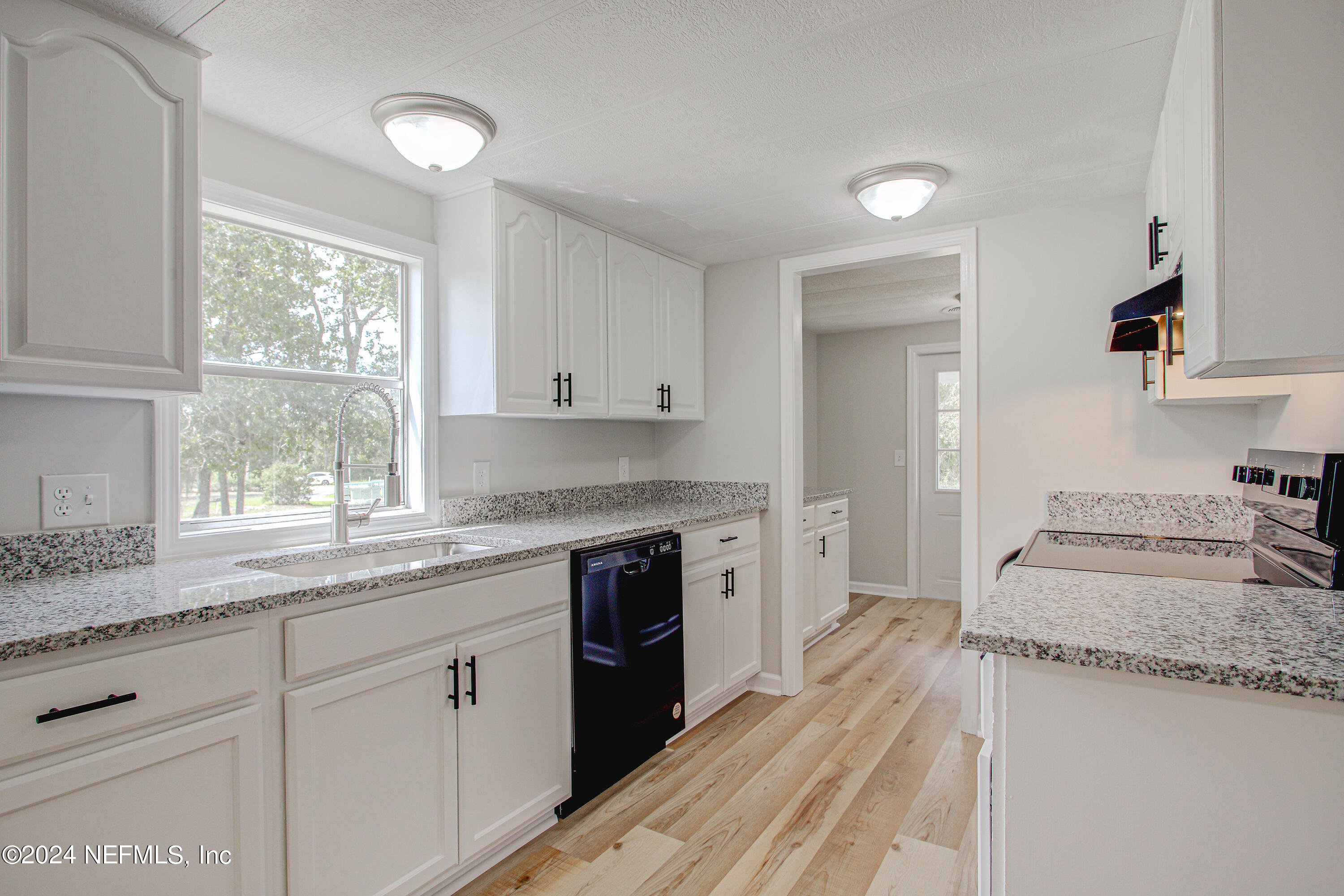 7677 Oak Forest Road Keystone Heights, FL 32656 - Photo 20 of 54 a kitchen with granite countertop white cabinets and white appliances